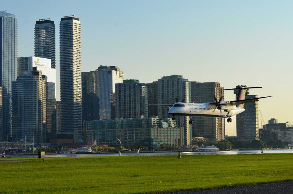 Close up plane landing with city skyline in background