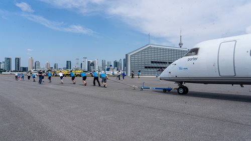 Group of individuals pulling an airplane using a rope