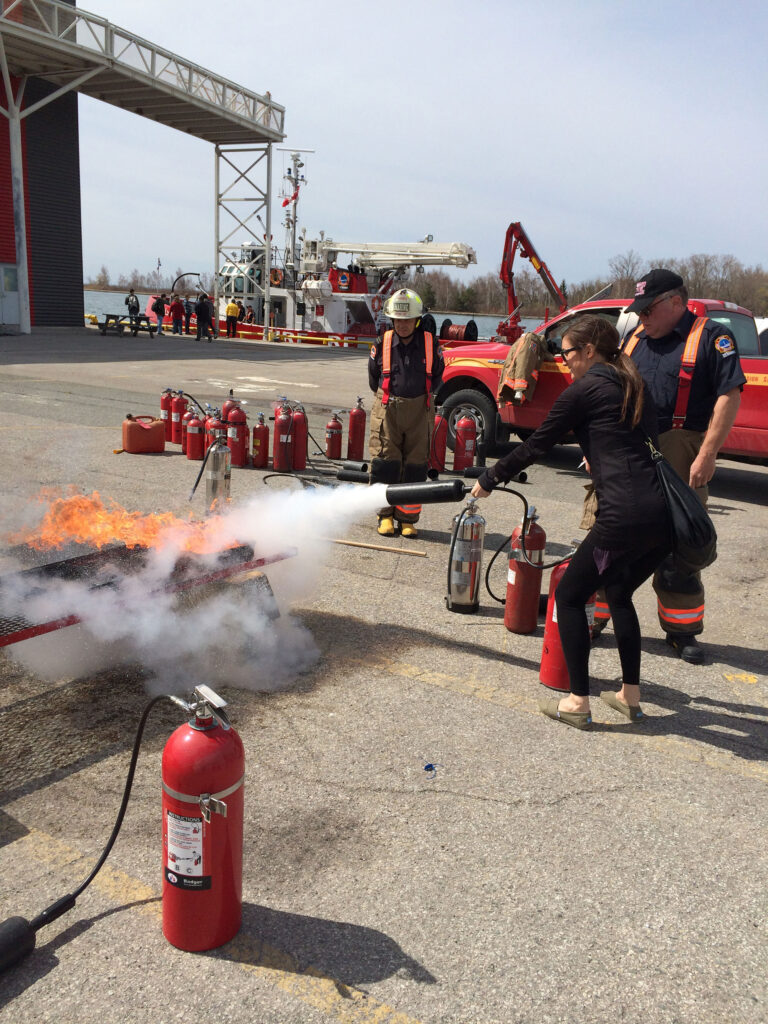 Lady using fire extinguisher to put out a fire