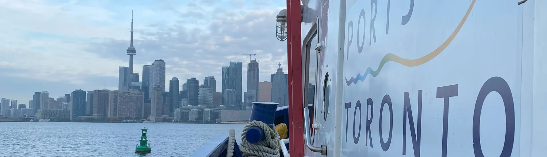 Photo of the PortsToronto logo on a ship with the Toronto City skyline in the background