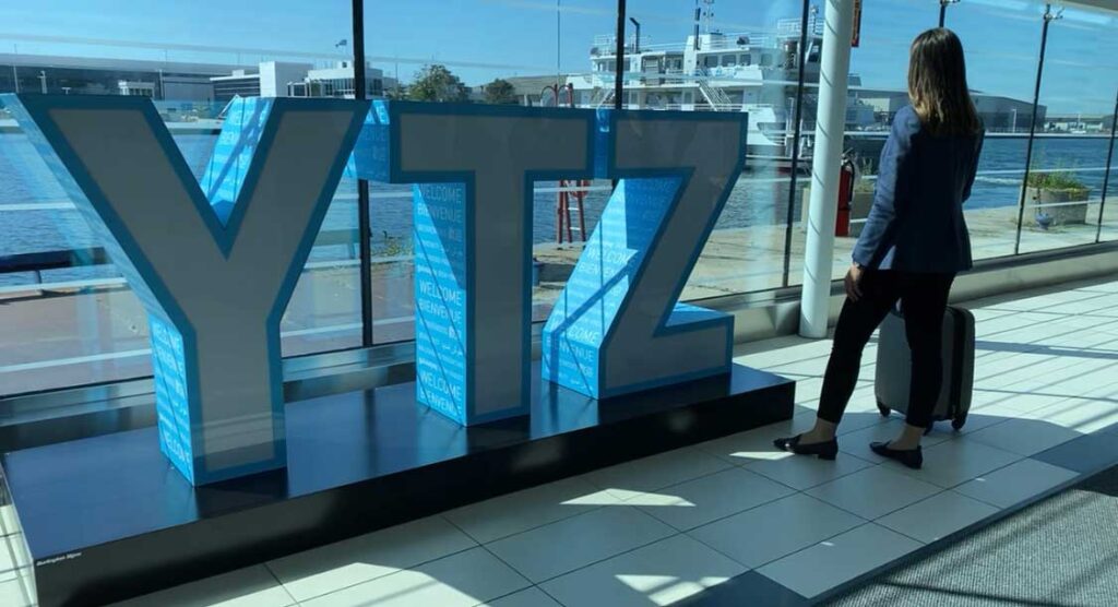 Lady standing by YTZ sign